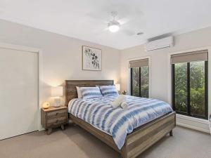 a bedroom with a bed with a blue and white comforter at 11a Railway Parade Wandin North in Wandin North