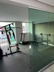 una camera con una palestra con una parete di vetro di Apartamento aconchegante de 3/4 na beira da praia! a Ilhéus