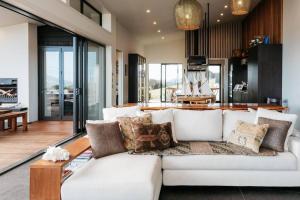 a living room with a white couch with pillows at Tradewinds Waiheke in Church Bay 