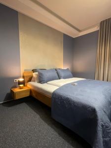 1 dormitorio con 1 cama grande y paredes azules en Hotel-Residenz-Luxury-Apartments en Metzingen