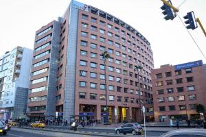 ein hohes Gebäude in einer Stadtstraße mit Autos in der Unterkunft Habitación privada – Super lugar in Bogotá