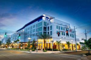 un gran edificio blanco con un cartel en el costado en Aloft Delray Beach, en Delray Beach