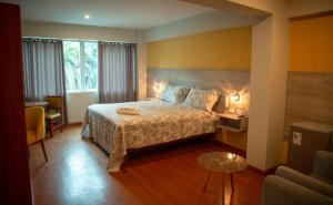 pokój hotelowy z łóżkiem i stołem w obiekcie HOTEL SUDAMERICANA INN w mieście Tacna