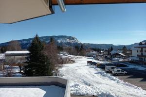 a view from the balcony of a snow covered town at Spacieux appartement au pied des pistes in La Féclaz