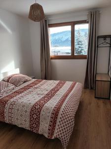 a bedroom with a bed and a large window at Spacieux appartement au pied des pistes in La Féclaz