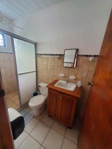 a bathroom with a toilet and a sink and a mirror at Hotel Villa Prats in Manuel Antonio