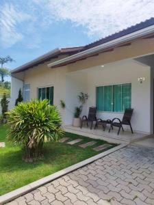 zwei schwarze Stühle auf der Veranda eines Hauses in der Unterkunft Casa com piscina em Zimbros in Bombinhas