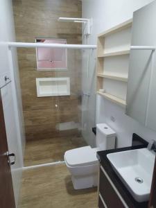a bathroom with a toilet and a sink at Casa com piscina em Zimbros in Bombinhas