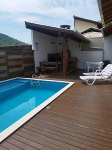 eine Terrasse mit einem Pool an einem Haus in der Unterkunft Casa com piscina em Zimbros in Bombinhas