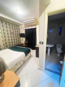 a bedroom with a bed and a bathroom with a sink at Golden Sun Hotel - Hurghada in Hurghada