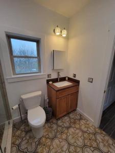 a bathroom with a toilet and a sink and a window at Modern, bright & calm 1 BR / 1 bath farm retreat in Penn Yan