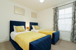 a bedroom with two beds and a window at Lovely Luxury 3 Bed House in Chatham