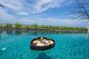 a tray of food in the middle of a pool of water at Lawira Beach Villa Lovina in Lovina