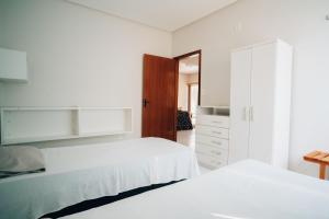 a bedroom with two beds and a closet at Casa de Praia com piscina em Luis Correia - Piaui in Luis Correia