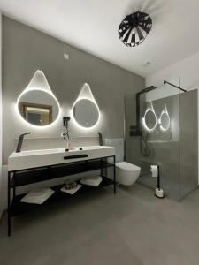 a bathroom with a sink and a mirror and a toilet at Hotel-Residenz-Luxury-Apartments in Metzingen