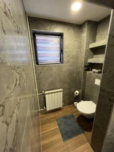 a bathroom with a toilet and a window at Cute and Cozy in Pale