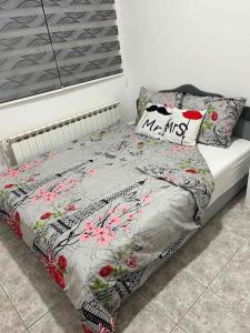 a bed with a floral comforter and pillows on it at Cute and Cozy in Pale