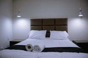 Una cama con dos rollos de papel higiénico. en PRANA, en Huancayo
