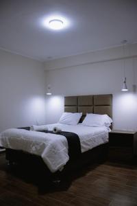 sypialnia z dużym łóżkiem z białą pościelą w obiekcie PRANA w mieście Huancayo