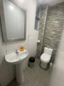 a bathroom with a sink and a toilet and a mirror at Huancayo Suite in Huancayo