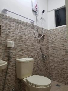 a bathroom with a toilet and a shower at JSS PENSION HOUSE 