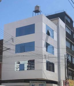un edificio blanco con ventanas azules encima en Huancayo Suite, en Huancayo