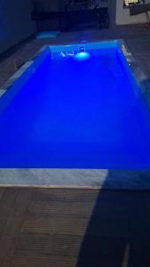a large blue swimming pool in a room at Nossa Casa com Piscina in Guarapari