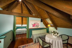 a attic room with a table and a bed at Hotel & Loisir Le Ruote in Roveleto