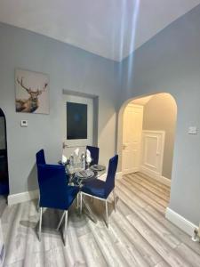 uma sala de jantar com uma mesa e cadeiras azuis em One Bedroom Ground Floor Flat In Central London em Londres