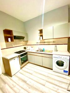 uma cozinha com uma máquina de lavar roupa e um lavatório em One Bedroom Ground Floor Flat In Central London em Londres