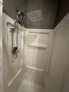 La salle de bains est pourvue d'une douche et d'une porte blanche. dans l'établissement Driftwood Cottage with Hot Tub on Lake Cumberland, à Russell Springs