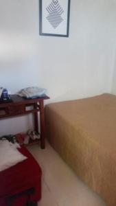 ein Schlafzimmer mit einem Bett und einem Tisch mit einem Bettrock in der Unterkunft Recanto da lua in Prado