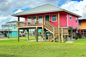 a red house with a deck in the grass at The Pink Flamingo Beach Gulf views in Freeport