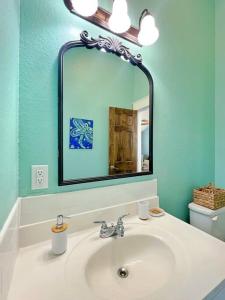 a bathroom with a sink and a mirror at The Pink Flamingo Beach Gulf views in Freeport
