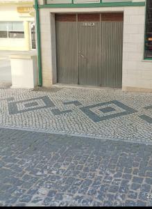 a building with a door and a brick sidewalk at SBT Sun Beach Terrace "The best house" in Figueira da Foz