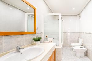 a bathroom with a sink and a toilet and a mirror at Goa Square by Lisbon with Sintra in Amadora