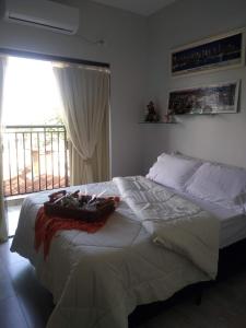 uma cama grande num quarto com uma janela em APTO Maison Class - 3 quartos próximo ao shopping em Foz do Iguaçu