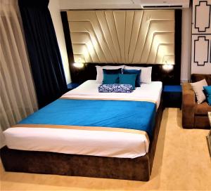 a bedroom with a large bed with blue pillows at Meeresbrise by Ocean Breaze in Negombo