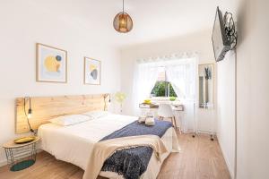 a white bedroom with a bed and a desk at Goa Square by Lisbon with Sintra in Amadora