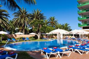 a pool at a resort with lounge chairs and umbrellas at Sol Puerto de la Cruz Tenerife in Puerto de la Cruz