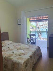 - une chambre avec un lit et une vue sur l'océan dans l'établissement Pousada e Restaurante J L ., à Mangaratiba