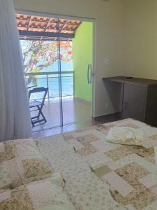 Schlafzimmer mit einem Bett und Meerblick in der Unterkunft Pousada e Restaurante J L . in Mangaratiba