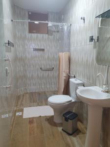 W łazience znajduje się toaleta, umywalka i prysznic. w obiekcie Pousada e Restaurante J L . w mieście Mangaratiba