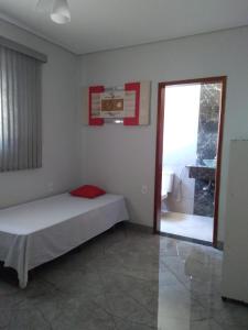 Schlafzimmer mit einem Bett und einer Glasschiebetür in der Unterkunft Área de Lazer e Hospedagem completa in Ribeirão Preto