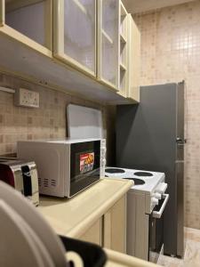 a kitchen with a stove and a microwave on a counter at شقة سكنية بغرفتين نوم in Al Jubail