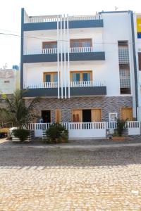 a white building with a palm tree in front of it at Apartamento em Santa Maria- Espaçoso&Confortável in Santa Maria