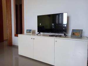 TV de pantalla plana en la parte superior de un armario blanco en Apartamento em Santa Maria- Espaçoso&Confortável en Santa María