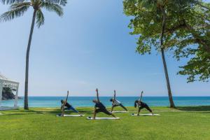 a group of people doing yoga on the beach at Phuket Marriott Resort & Spa, Merlin Beach in Patong Beach