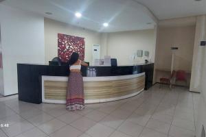 a woman standing at a counter in a lobby at Flat Biarritz em São Luís com excelente localização! in São Luís