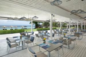 巴東海灘的住宿－Phuket Marriott Resort & Spa, Merlin Beach，一间在甲板上配有桌椅的餐厅